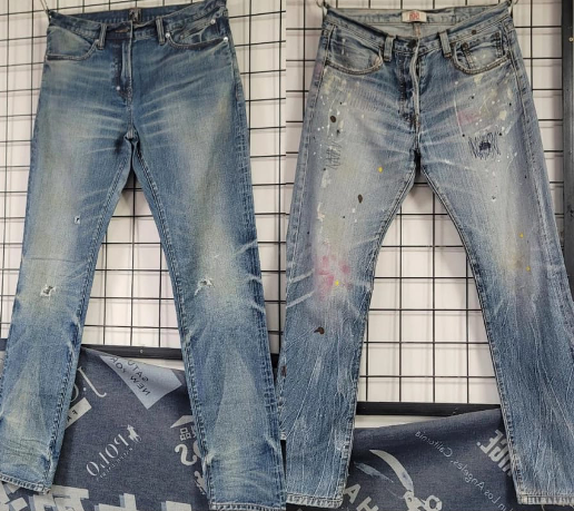 Two pairs of light-wash denim jeans with distressing and paint effects after wash.